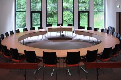 Byrådssal Mariagerfjord Kommune med stort ovalt bord med stole omkring